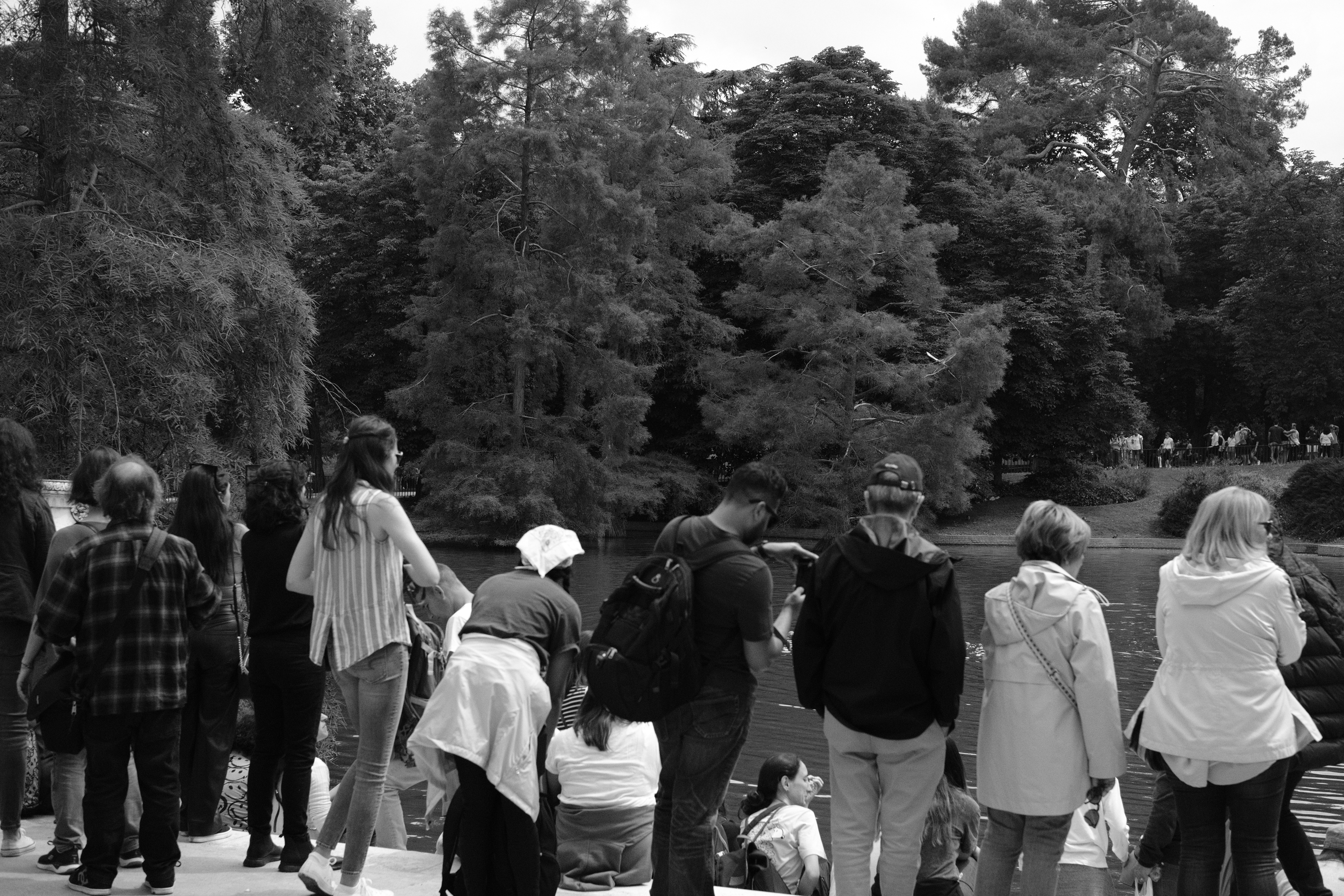 tourists and locals gather around the pond at the Crytal Palace at Retiro Park, Madrid.